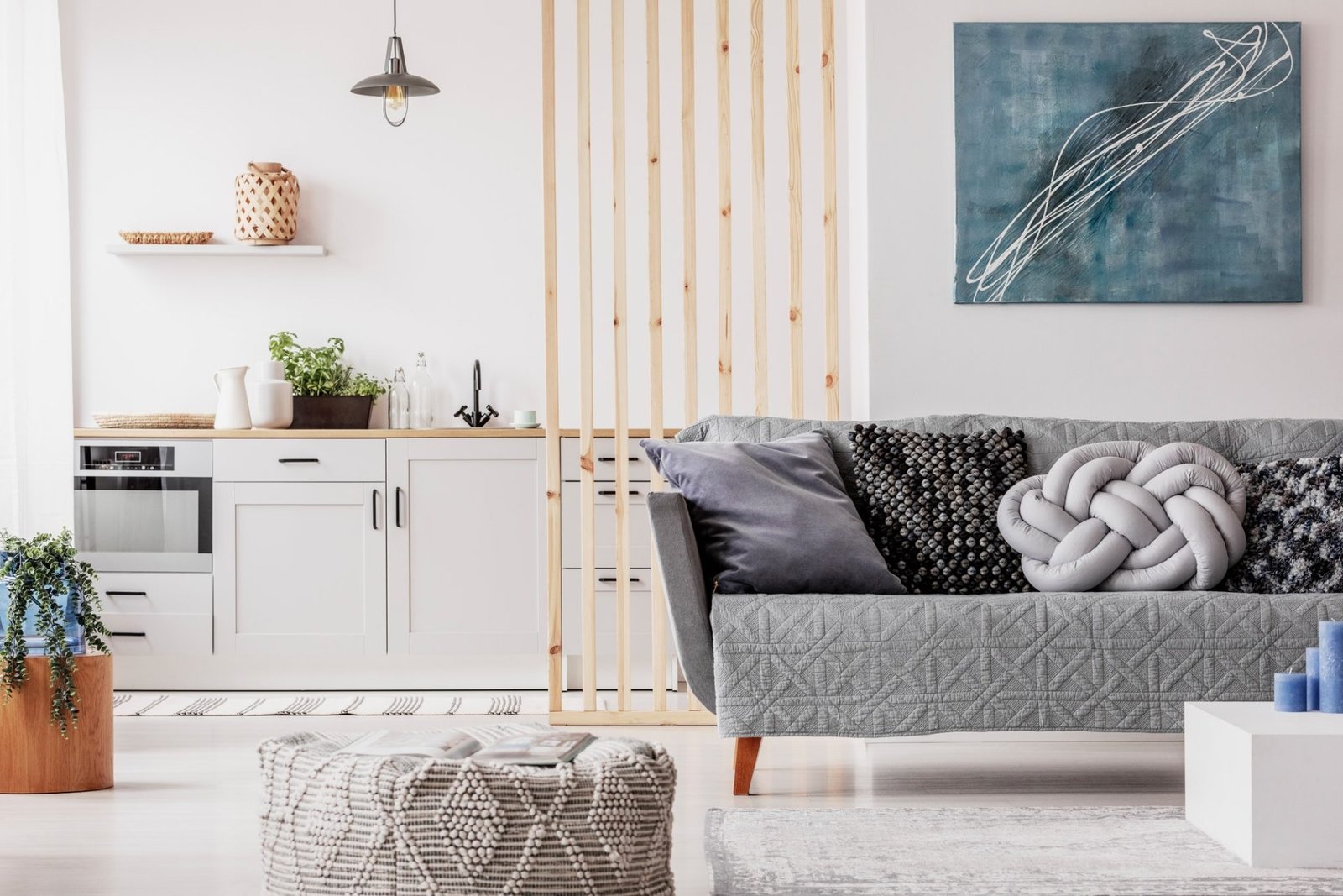 abstract blue painting on empty white wall of open plan apartment e1647338796528