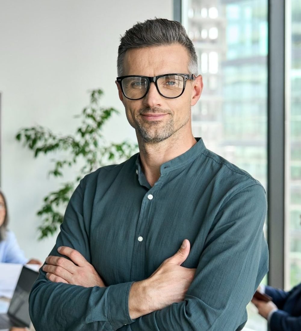 smiling confident mature businessman leader looking at camera in office e1647498676549